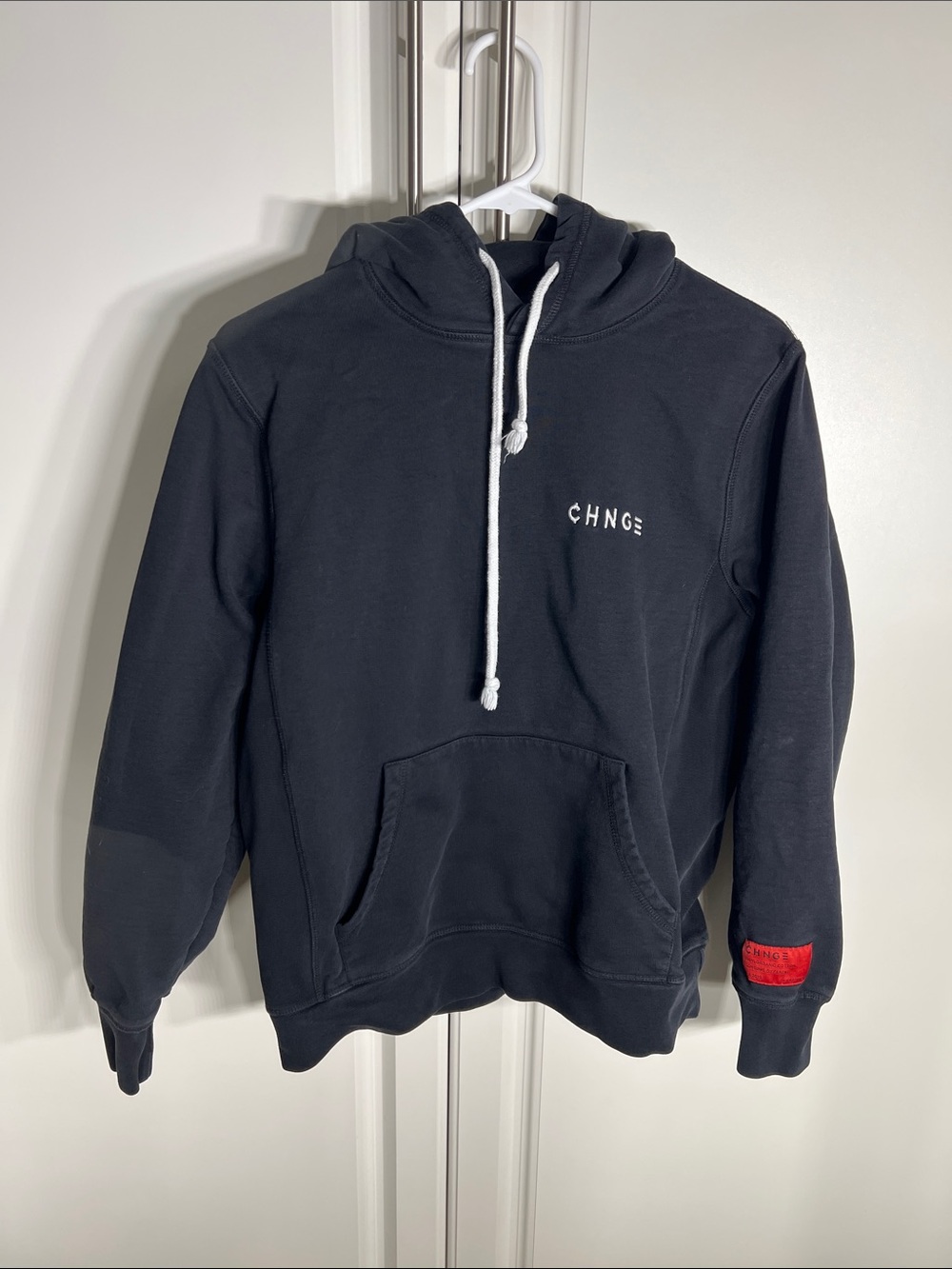 CHNGE Black Hoodie with White Drawstrings and Red Sleeve Patch